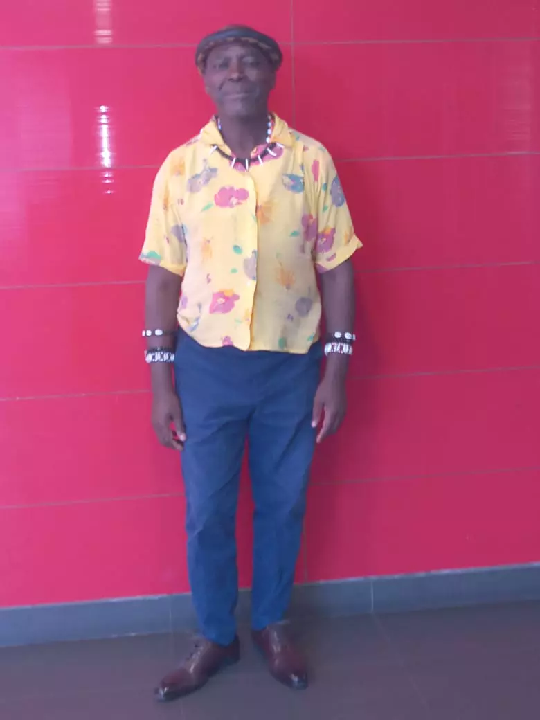 Emperor Thembu 2nd Votani Majola in a patterned yellow shirt against a red wall